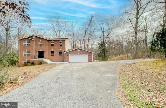 view of front facade featuring an outbuilding, brick siding, and a garage