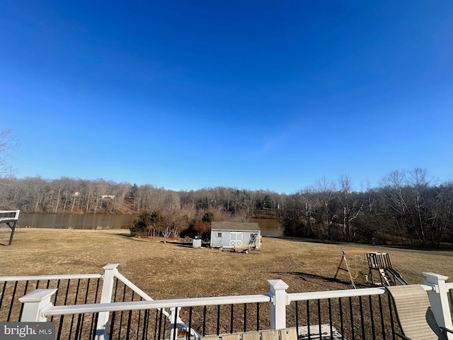 view of yard with a storage unit, a water view, and an outdoor structure