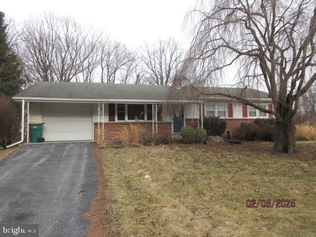 ranch-style house featuring a garage and a front yard