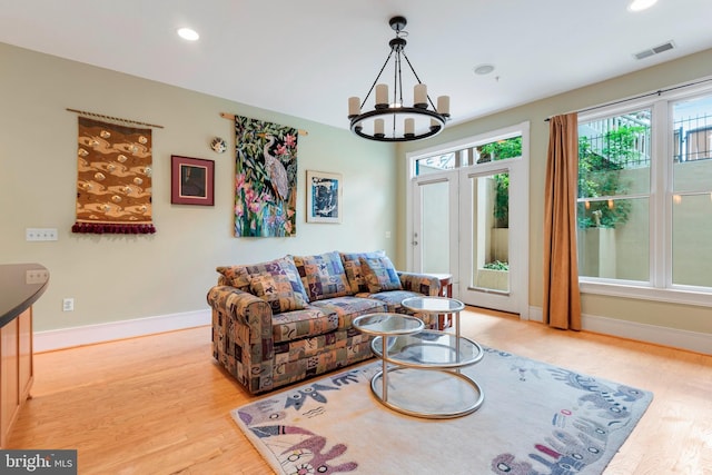 living room with an inviting chandelier and light wood-type flooring