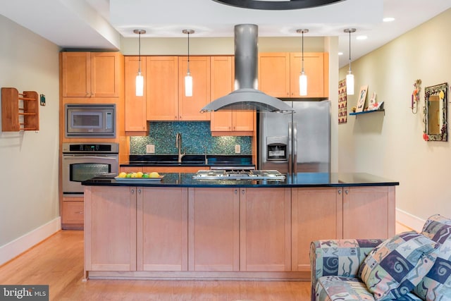 kitchen with sink, island range hood, pendant lighting, stainless steel appliances, and backsplash