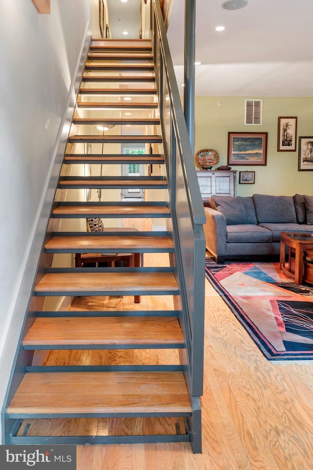 stairs with hardwood / wood-style flooring