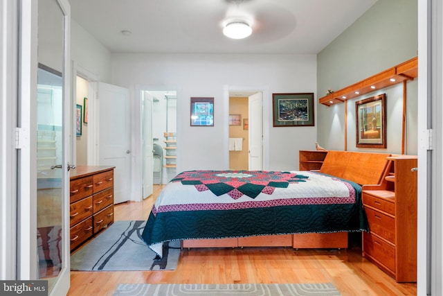 bedroom with ensuite bathroom and light hardwood / wood-style flooring