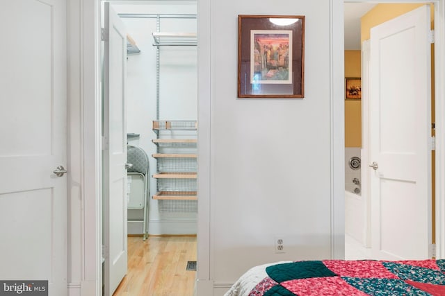 bedroom with light hardwood / wood-style floors and a closet