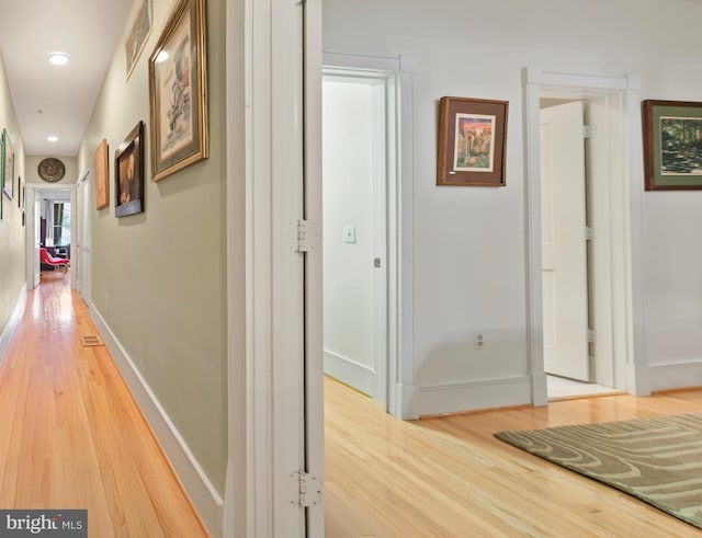 hallway with hardwood / wood-style flooring