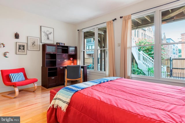 bedroom with hardwood / wood-style flooring and access to outside