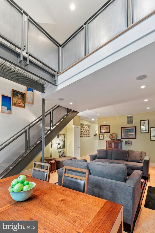 dining area with light wood-type flooring and a high ceiling