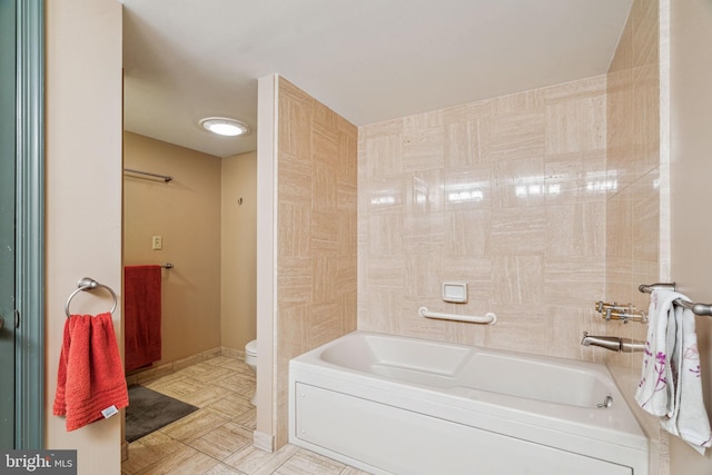 bathroom featuring baseboards and toilet