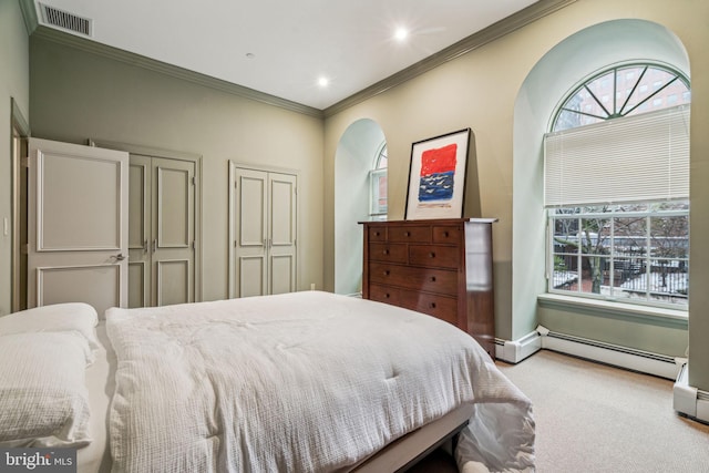 carpeted bedroom with a baseboard radiator, visible vents, crown molding, and baseboards