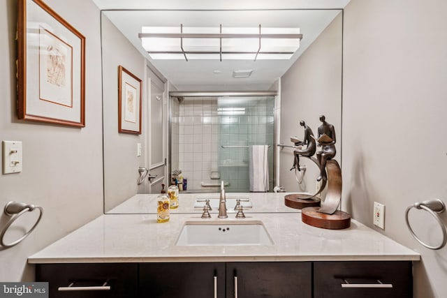 full bath with a tile shower and vanity