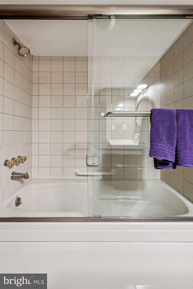 full bathroom with bath / shower combo with glass door and tile walls