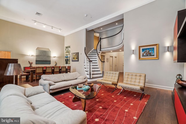 living area featuring wood-type flooring, visible vents, ornamental molding, and stairs