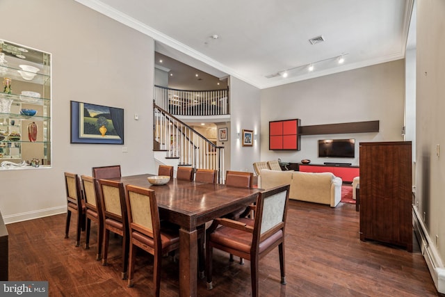 dining area featuring stairs, crown molding, baseboard heating, and wood finished floors