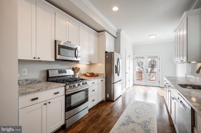 kitchen with french doors, light stone counters, appliances with stainless steel finishes, white cabinets, and crown molding