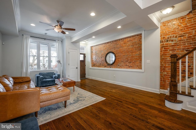 living room with dark hardwood / wood-style flooring, ornamental molding, brick wall, and ceiling fan