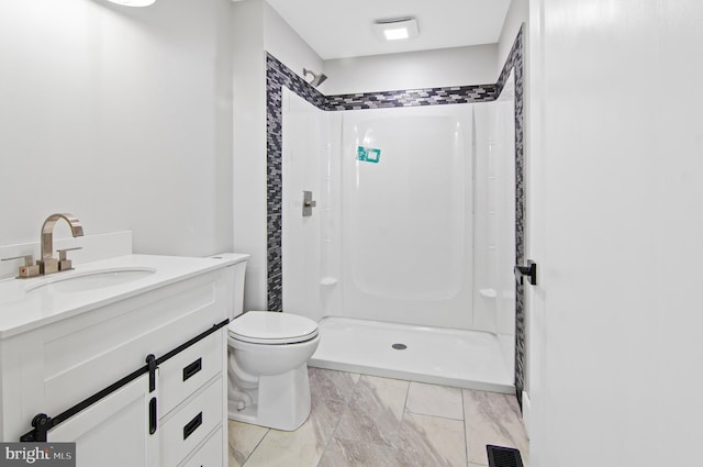 bathroom with vanity, a shower, and toilet