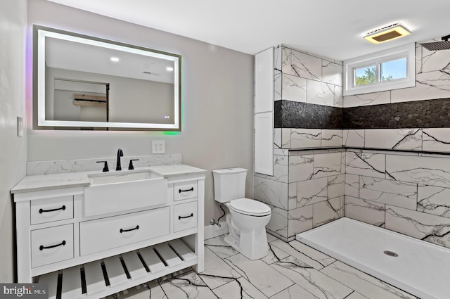 bathroom featuring tiled shower, vanity, and toilet