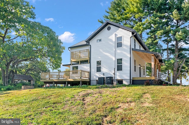 back of property featuring cooling unit, a lawn, and a balcony