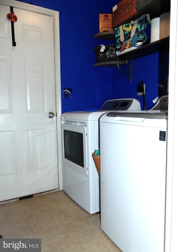 clothes washing area with separate washer and dryer