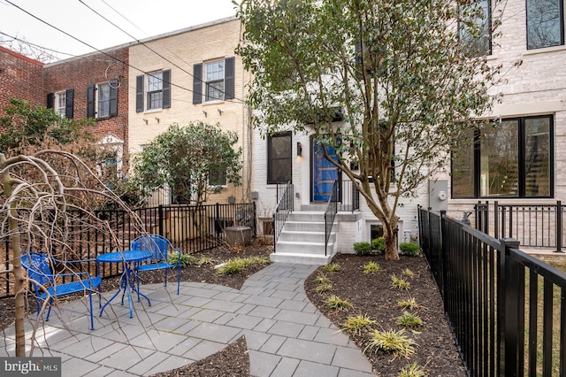 exterior space featuring brick siding, a patio area, and fence