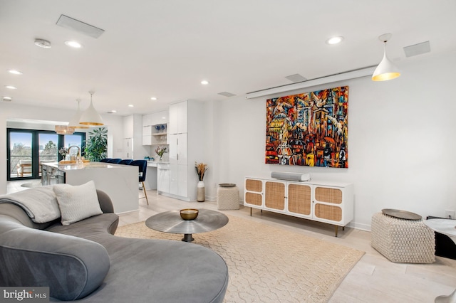 living area featuring baseboards and recessed lighting