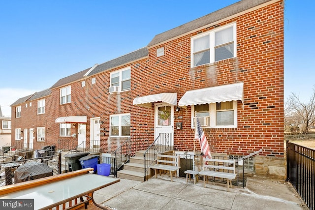 townhome / multi-family property featuring brick siding, fence, and a patio