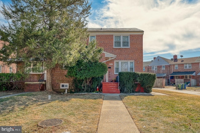 view of front facade with a front lawn and brick siding