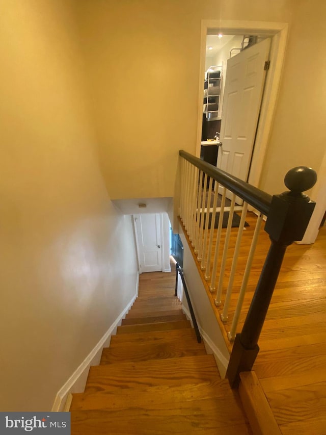 stairs featuring hardwood / wood-style floors