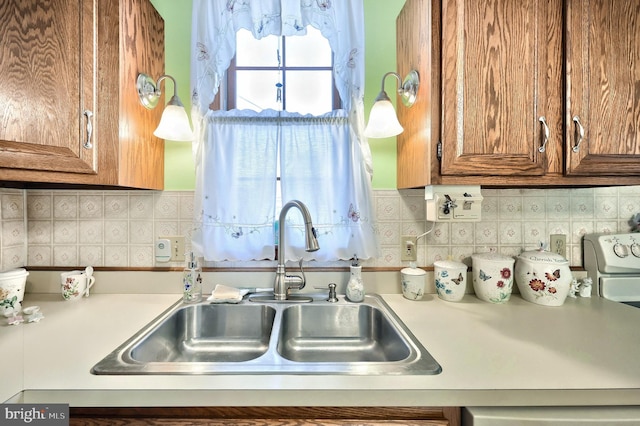 kitchen featuring sink, backsplash, and decorative light fixtures