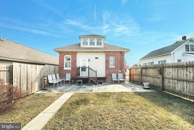 back of property with a patio area and a yard