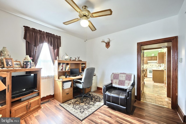 home office featuring ceiling fan and light hardwood / wood-style flooring