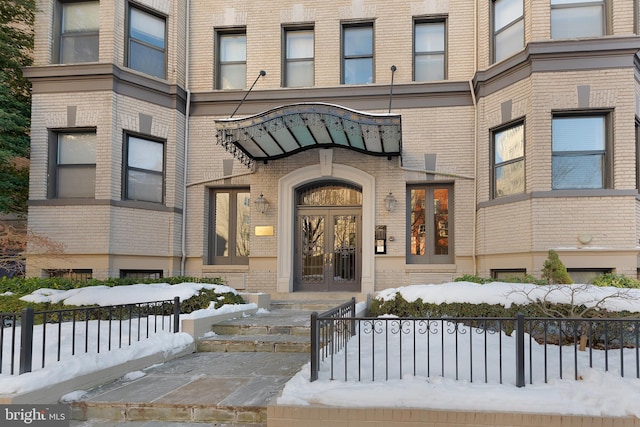 snow covered property entrance with french doors