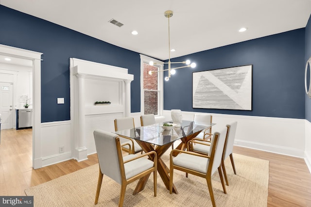 dining room with a wainscoted wall, light wood-type flooring, visible vents, and recessed lighting