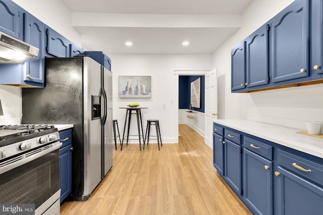 kitchen featuring under cabinet range hood, blue cabinets, light countertops, light wood-type flooring, and gas stove