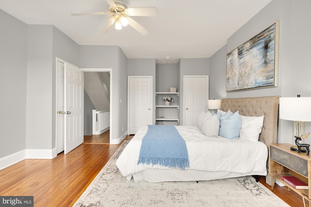 bedroom featuring a ceiling fan, baseboards, and wood finished floors