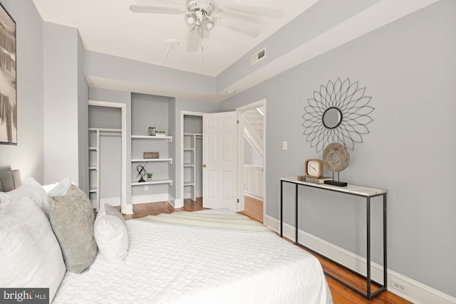 bedroom with visible vents, ceiling fan, baseboards, and wood finished floors