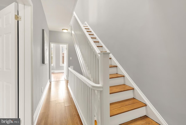 stairway with baseboards and wood finished floors