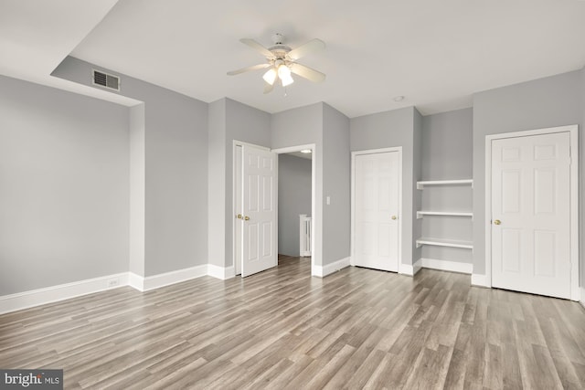 unfurnished bedroom featuring light wood-style flooring, a ceiling fan, visible vents, and baseboards