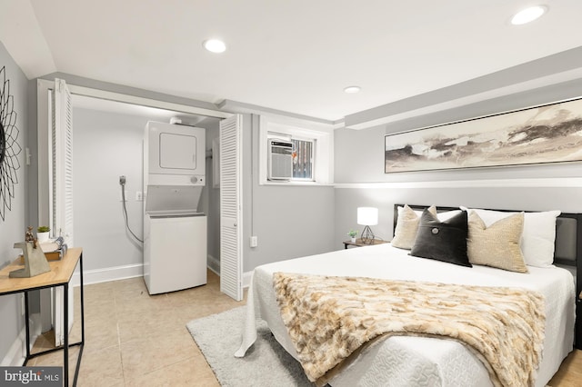 bedroom with light tile patterned floors, baseboards, a wall unit AC, stacked washer / drying machine, and recessed lighting