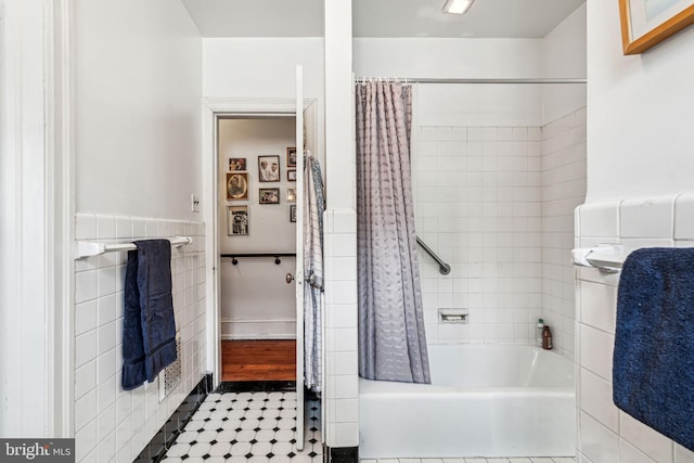 full bathroom with tile walls, tile patterned flooring, and shower / bathtub combination with curtain