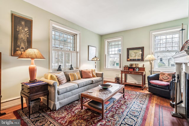 living room with a fireplace with flush hearth, baseboards, dark wood-style flooring, and a wealth of natural light