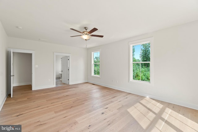 unfurnished bedroom featuring light wood-type flooring, connected bathroom, and ceiling fan