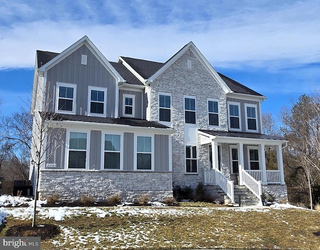 view of front of home featuring board and batten siding, stone siding, metal roof, and a standing seam roof