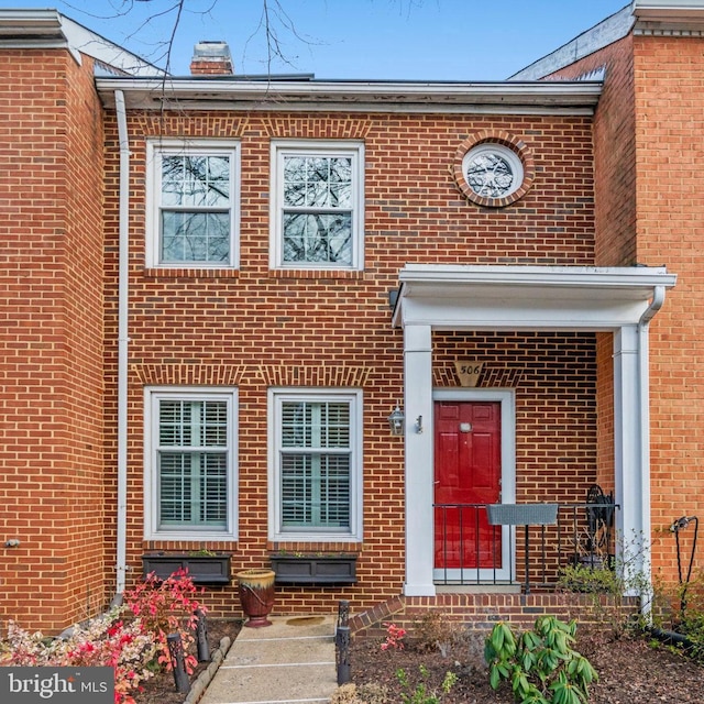 multi unit property with a chimney and brick siding