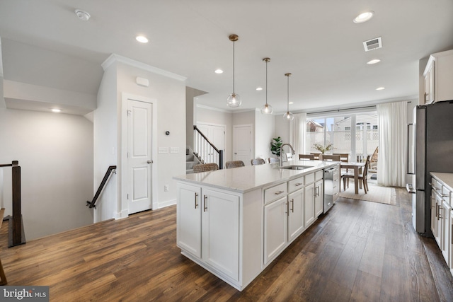 kitchen with a center island with sink, visible vents, white cabinets, stainless steel appliances, and a sink