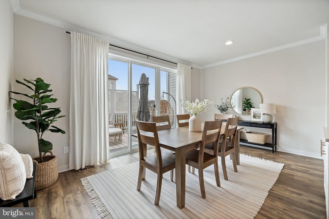 dining space with ornamental molding, dark wood-type flooring, and baseboards