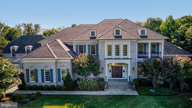 french provincial home with a front lawn