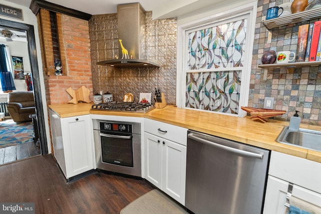 kitchen with white cabinetry, stainless steel appliances, dark hardwood / wood-style floors, and wall chimney exhaust hood