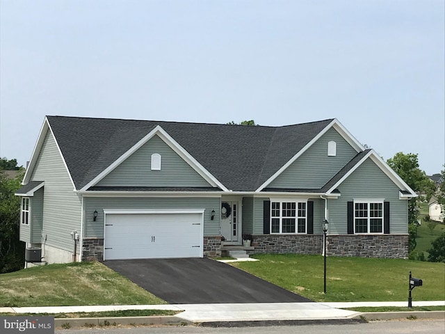 craftsman inspired home featuring cooling unit, a garage, and a front lawn