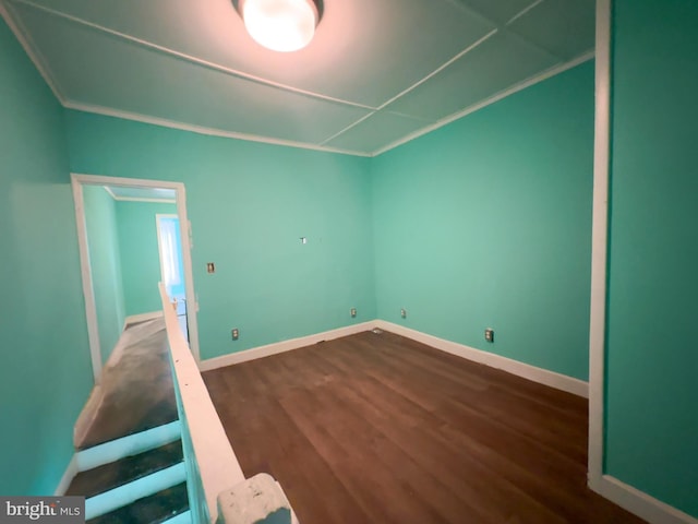 interior space featuring crown molding, baseboards, and dark wood-style flooring